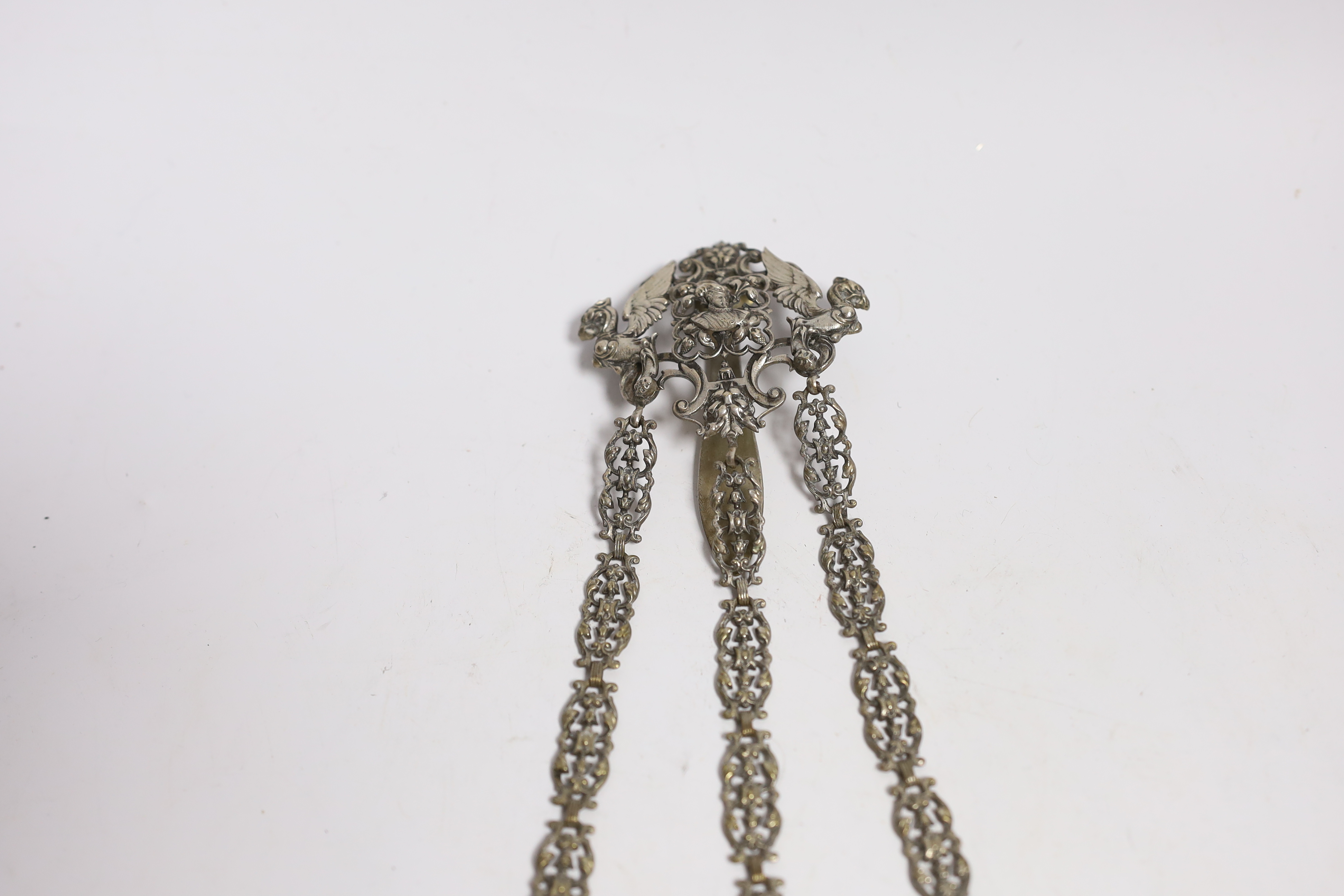 A late 19th century pierced silver plated chatelaine, hung with three accoutrements, to include a cased pair of scissors, pin cushion and thimble holder, overall 29.5cm.